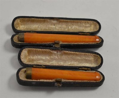 Lot 110 - Two amber cheroot holders in leather cases