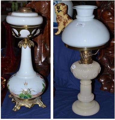 Lot 126 - A Victorian white opaque glass oil lamp painted with flowers, on four brass lion paw feet, and...