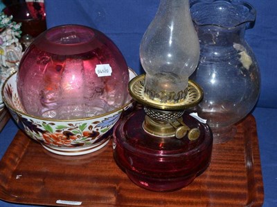 Lot 132 - A cranberry glass oil lamp font, an etched cranberry glass shade, a clear shade and a Japan pattern
