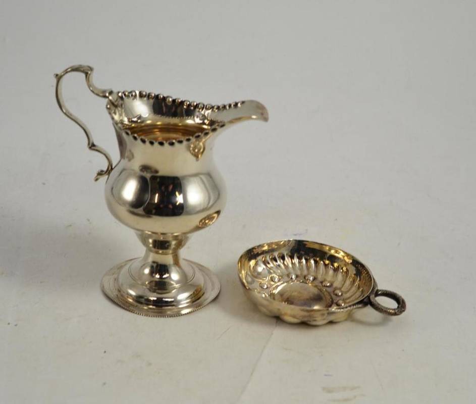 Lot 164 - A George V silver baluster cream jug, Birmingham 1912 and a Continental tastevin