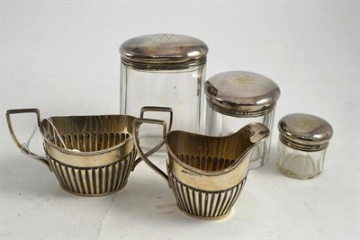 Lot 212 - A silver cream jug, a sugar bowl, a silver topped bottle and two others (5)