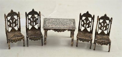 Lot 220 - Five pieces of sterling silver miniature furniture comprising table and four chairs