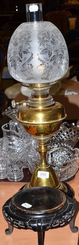 Lot 233 - A Victorian brass oil lamp with frosted shade and a Chinese carved wooden stand