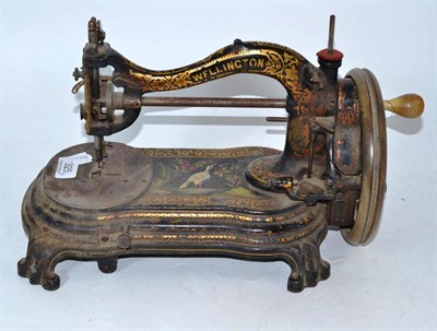 Lot 325 - A Victorian painted cast iron sewing machine by Wellington and a rug beater