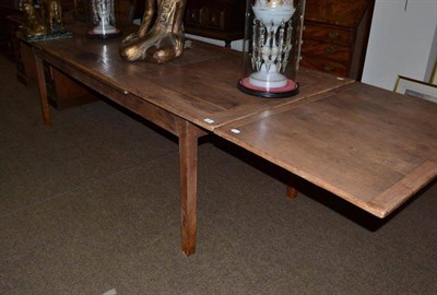 Lot 424 - An oak farm house kitchen table with pull-out leaves
