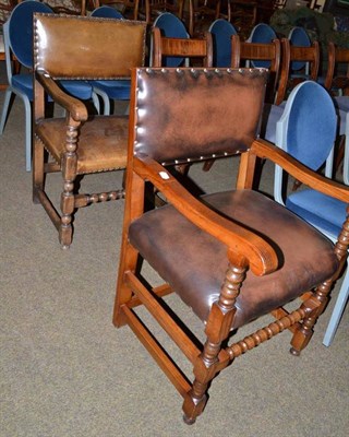 Lot 439 - Two oak and leather elbow chairs