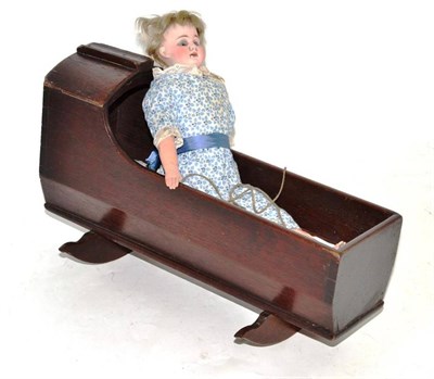 Lot 290 - A German bisque shoulder head girl doll, with composition lower limbs, in a mahogany cradle