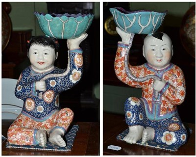 Lot 483 - A pair of Imari type male and female figures with shallow bowls on top