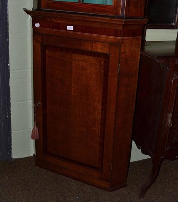 Lot 628 - A Georgian oak straight front corner cupboard cross banded in mahogany