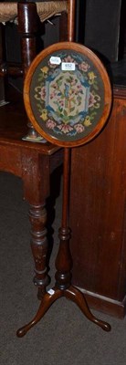 Lot 652 - A mahogany pole screen with oval needlework banner