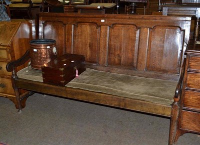 Lot 676 - An 18th century oak four panel back settle