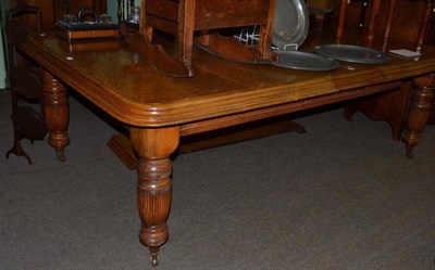 Lot 687 - Victorian oak extending dining table with two leaves and winder