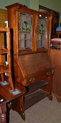 Lot 762 - An Arts and Crafts oak bureau bookcase with stained glass panel doors