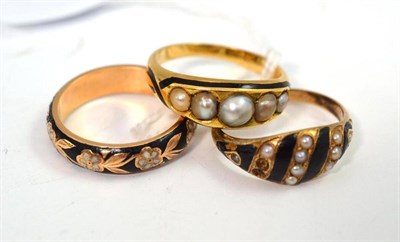 Lot 31 - Two pearl set and black enamel rings and a black and white enamel ring (3)