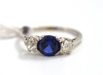 Lot 191 - A sapphire and diamond three stone ring, the round brilliant cut sapphire set between two old...