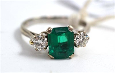 Lot 217 - A synthetic emerald and diamond three stone ring, the emerald-cut emerald flanked by a round...