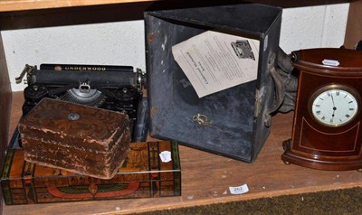 Lot 262 - An Edwardian bow fronted mahogany mantel timepiece, a spelter figure, two boxes and a typewriter