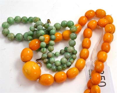 Lot 350 - A strand of graduated yellow amber beads, 24.6g and a strand of green beads (2)