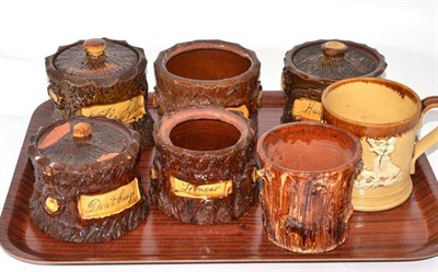 Lot 407 - Five late 19th century rusticware tobacco jars modelled as tree trunks, each with inscribed...