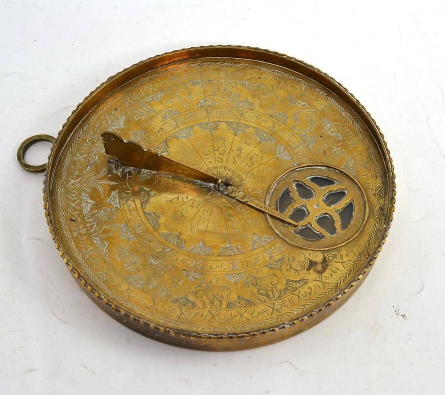 Lot 97 - An Islamic style brass compass/sundial, with folding gnomon, suspension ring, diameter 17cm