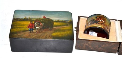 Lot 253 - A Russian papier mache box and cover with harvesting scene and a napkin ring, boxed (2)