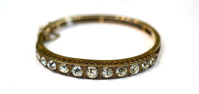 Lot 386 - A graduated paste set bangle with foil backed stones