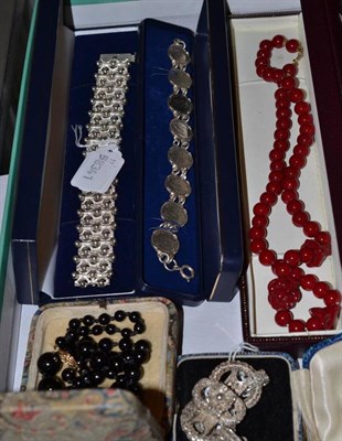 Lot 392 - A contemporary silver bracelet, a filigree pendant brooch, a coin bracelet and two bead necklaces