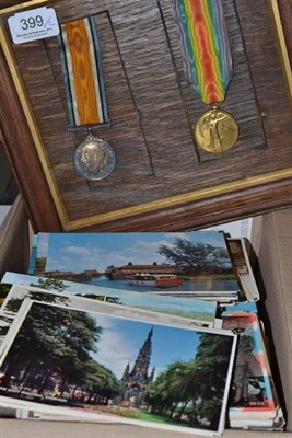 Lot 399 - A collection of postcards and two framed service medals