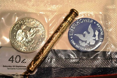 Lot 402 - A 9ct gold pencil and a silver dollar