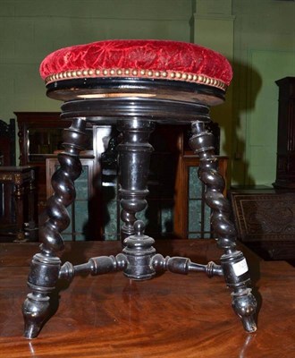 Lot 523 - A Victorian ebonised revolving piano stool on barley twist legs