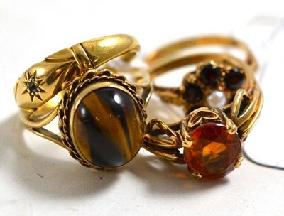 Lot 50 - Four dress rings including a 9ct gold ring, a tiger's-eye ring, a cultured pearl and garnet cluster