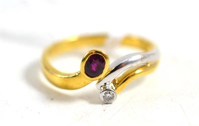 Lot 194 - A two colour ruby and diamond cross over ring stamped '750'