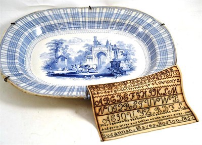 Lot 234 - A 19th century earthenware meat platter decorated with cattle before a ruin and a sampler worked by