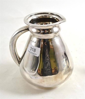 Lot 318 - An Irish silver water jug in the design of a water jar, with applied silver tube handle, Dublin...