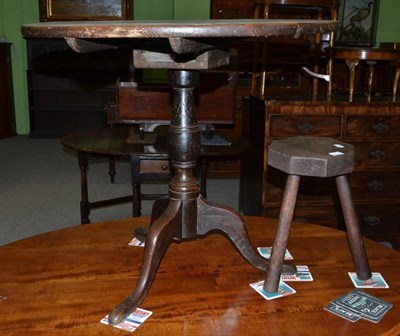 Lot 497 - A George III oak tilt top table and a milking stool