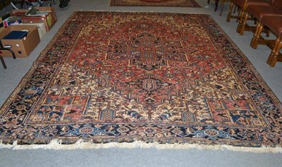 Lot 686 - A Heriz carpet, Persian Azerbaijan, the raspberry field of angular vines around a typical medallion