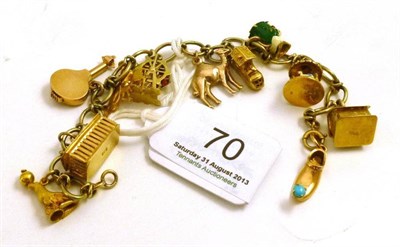 Lot 70 - A charm bracelet hung with various charms including one stamped '750' and one 'K18'