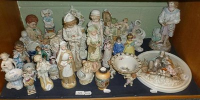 Lot 125 - A shelf of Continental bisque and porcelain figures, encrusted centrepieces and a figural roundel