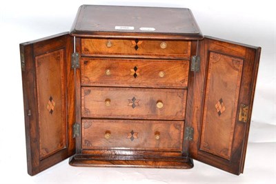 Lot 292 - An inlaid walnut collector's cabinet with two cupboard doors enclosing four graduated drawers