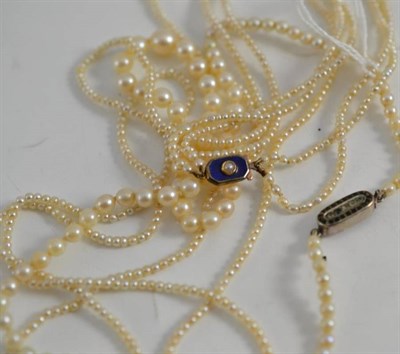 Lot 414 - Double string of seed pearls with a blue enamelled clasp and another string of cultured pearls