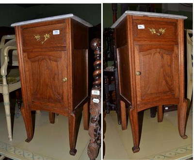 Lot 599 - Pair of oak pot cupboards with marble tops