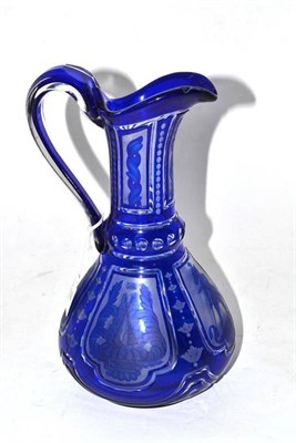 Lot 19 - A Bohemian Blue Flashed Clear Glass Ewer, late 19th century, of tapering cylindrical form, engraved