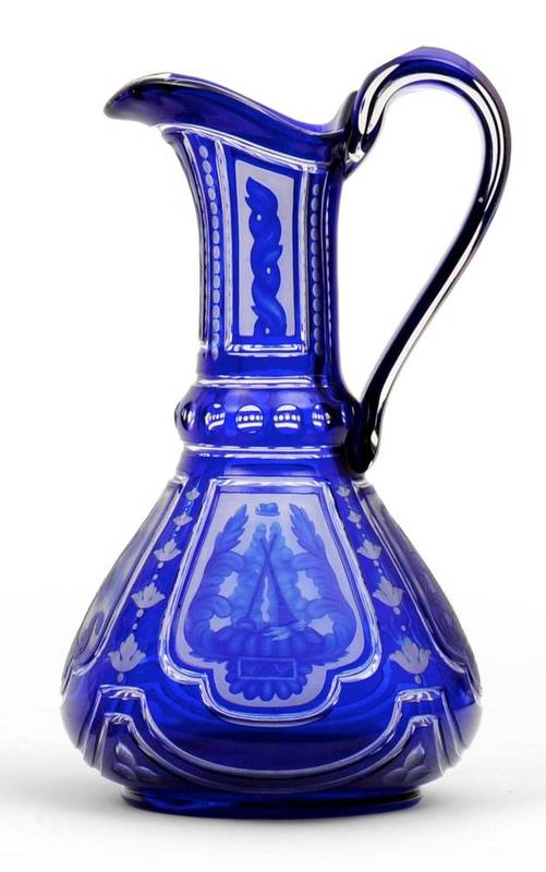 Lot 20 - A Bohemian Blue Overlay Clear Glass Ewer, mid 19th century, with cylindrical neck, loop handle...