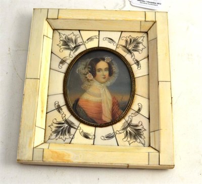 Lot 73 - A miniature of a lady wearing pearls, lace bonnet and peach dress signed Dupre, in ivory frame