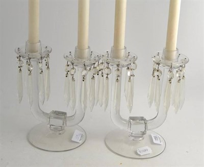 Lot 159 - A pair of 19th century clear glass twin-branch candlesticks with facet-cut drops