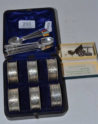 Lot 233 - A set of six silver napkin rings, a set of six silver tea spoons, four silver and enamel coffee...