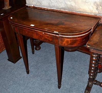 Lot 472 - A mahogany fold over tea table on spade feet