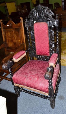 Lot 499 - A Victorian heavily carved oak elbow chair with red tasselled upholstery