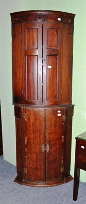 Lot 536 - An oak bow fronted corner cupboard and a mahogany bow fronted corner cupboard (2)