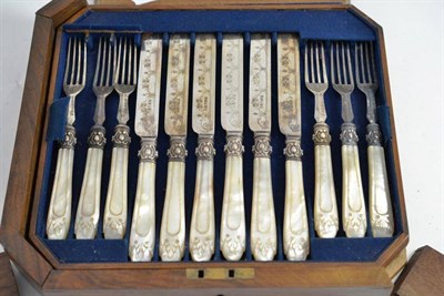 Lot 126 - A set of twelve close plate dessert knives and forks with mother-of-pearl handles in damaged walnut